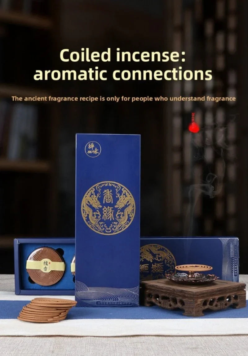 Coiled incense sticks and elegant blue packaging with gold dragon design, burning incense on wooden holder