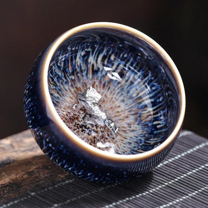Blue ceramic bowl with intricate pattern and silver foil decoration on wooden surface