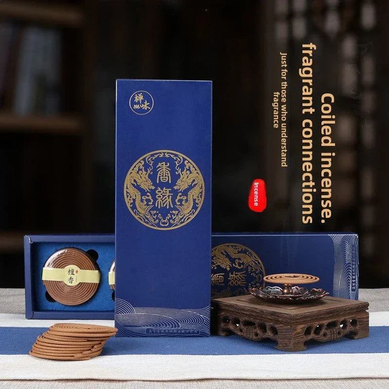 Coiled incense sticks with blue and gold packaging and wooden incense holder with smoke