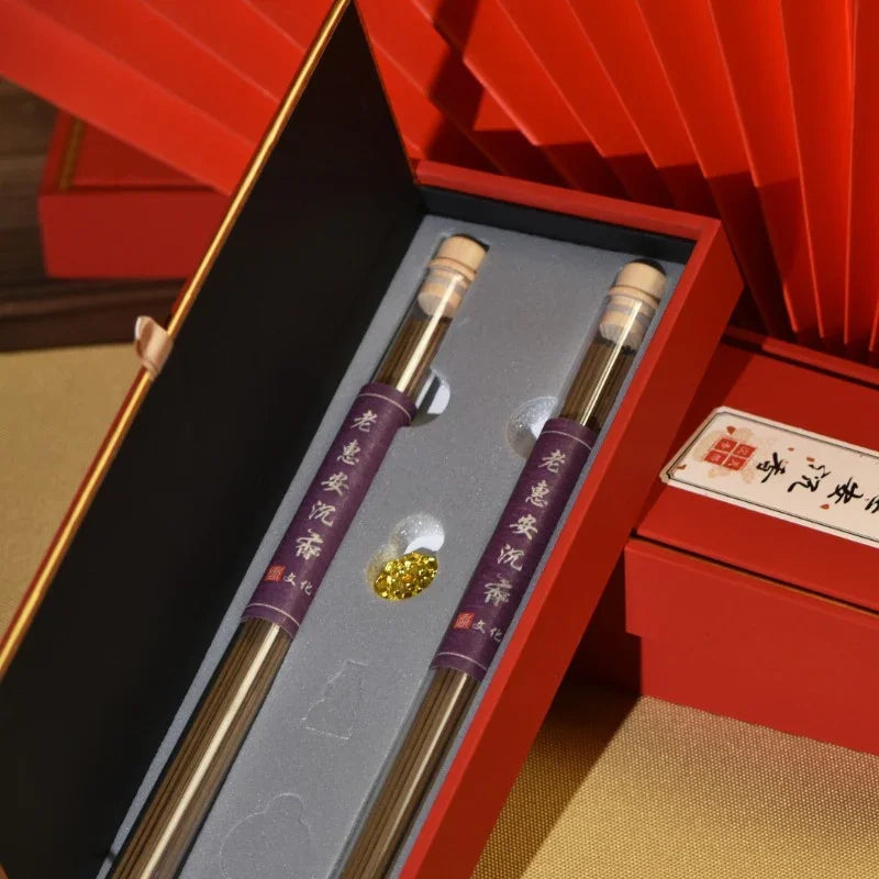 Red gift box containing two glass tubes with incense sticks and golden incense granules