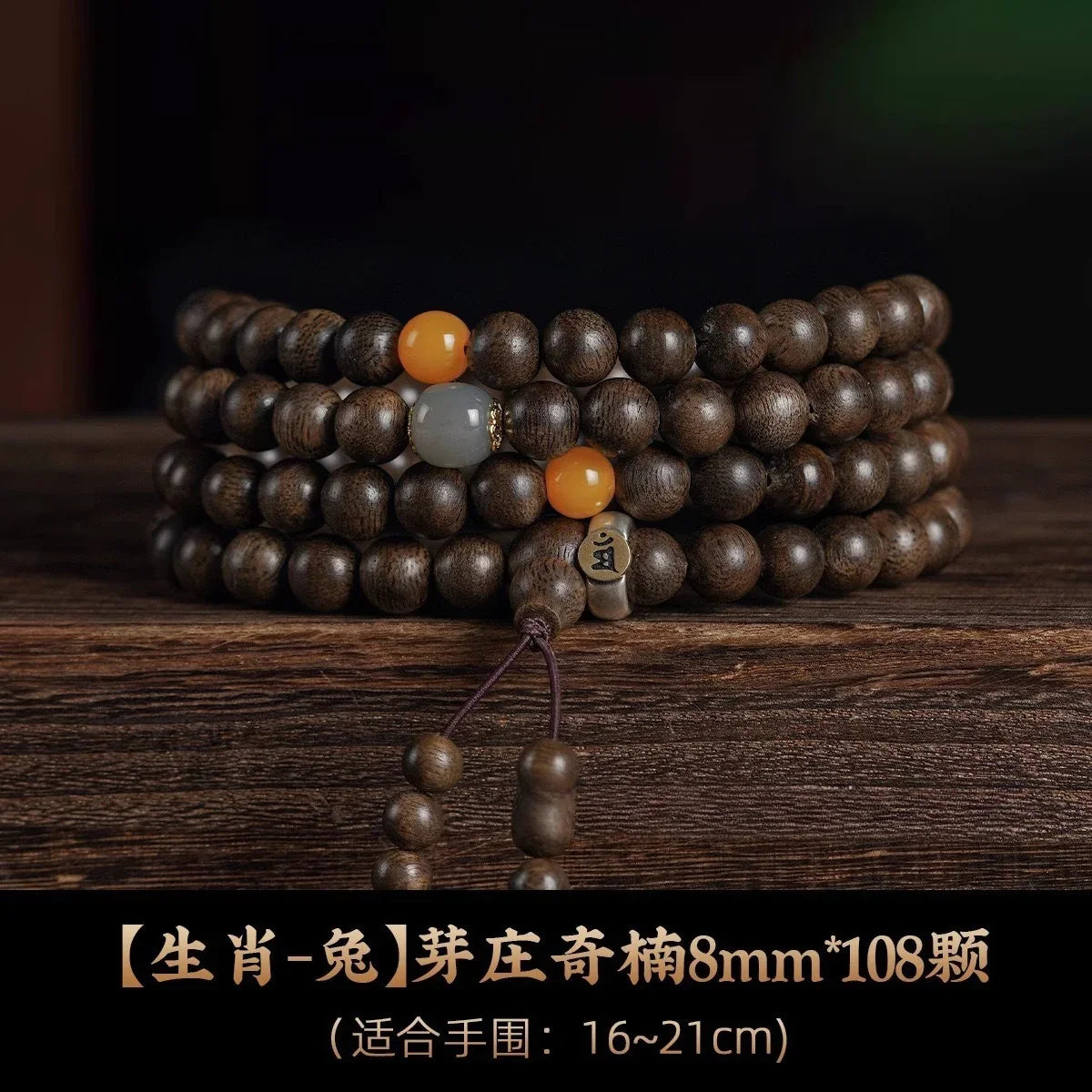 108-bead 8mm dark wooden mala bracelet with orange and gray accent beads on wooden surface