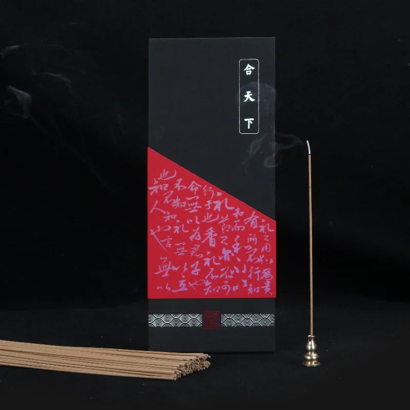 Black and red incense stick box with Chinese calligraphy, burning incense stick in brass holder