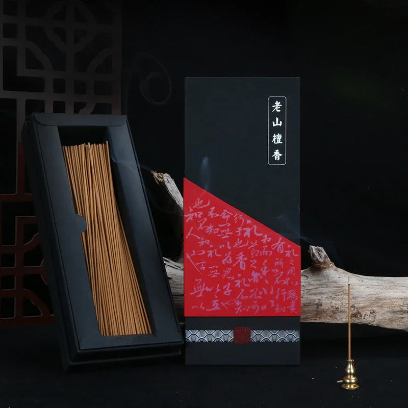 Black and red box of traditional Chinese incense sticks with wooden incense holder and smoky incense stick