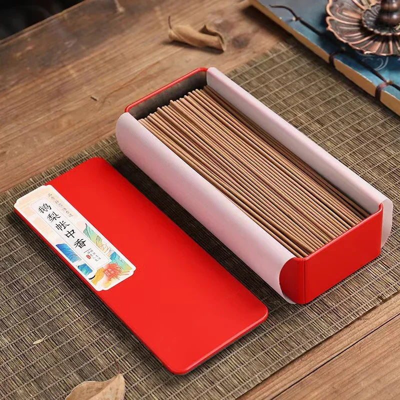 Rectangular box of neatly arranged incense sticks with red lid and Chinese label on woven mat