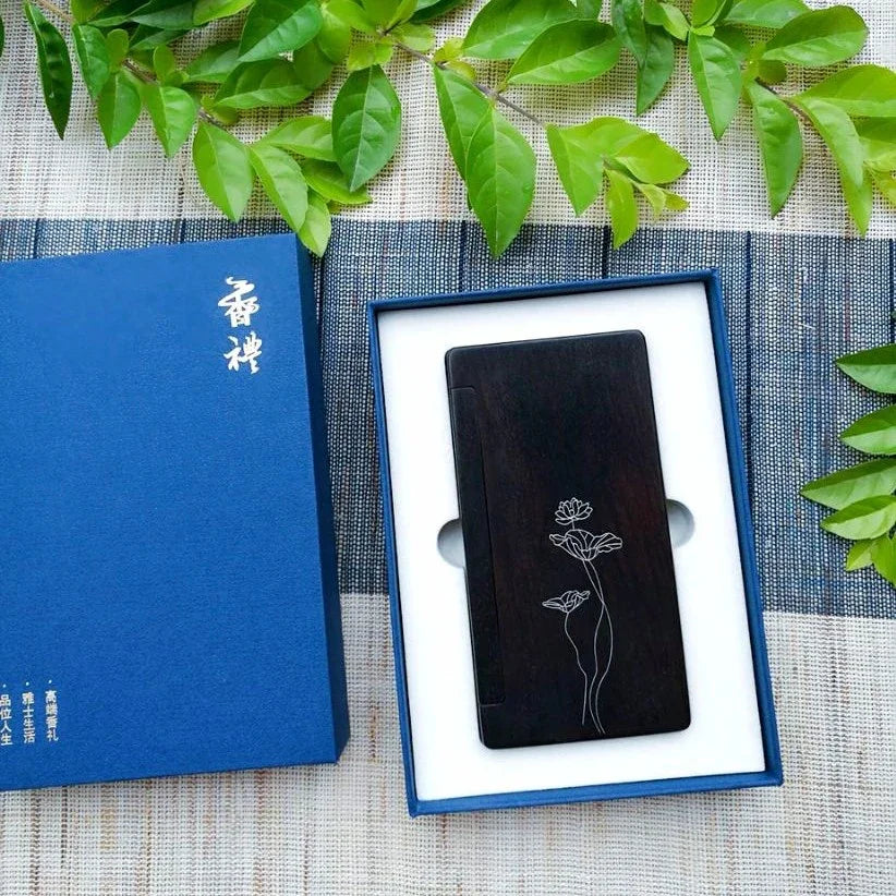 Elegant black wooden box with lotus flower design inside blue luxury gift box on fabric