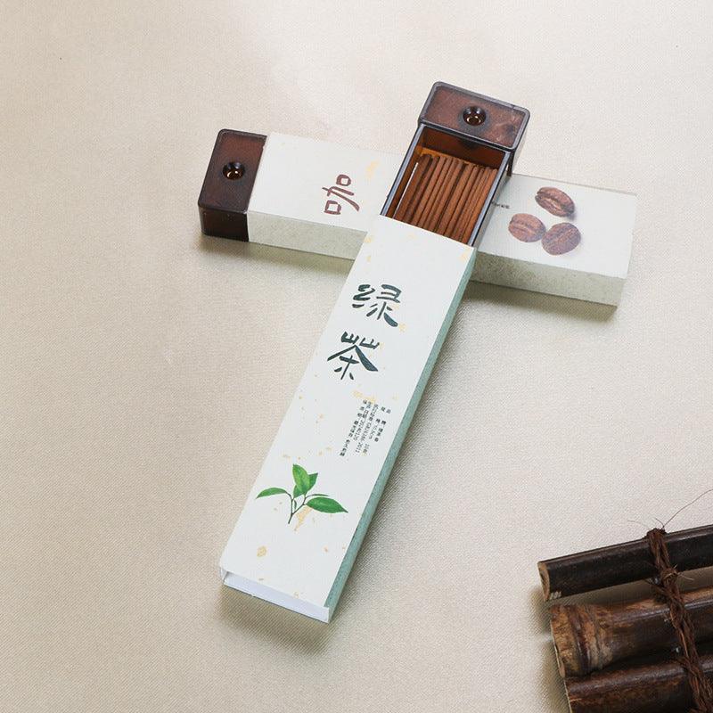 Traditional Japanese incense sticks in rectangular paper boxes with calligraphy and coffee bean illustrations