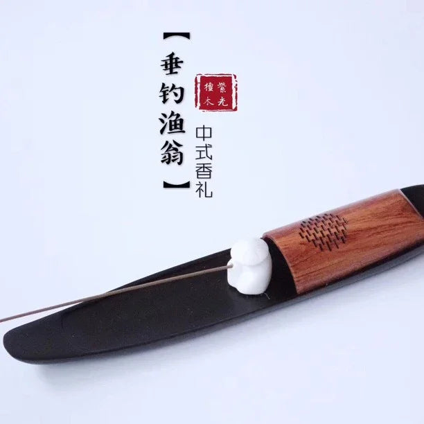Traditional Chinese-style incense holder with wooden and black design and small white figurine