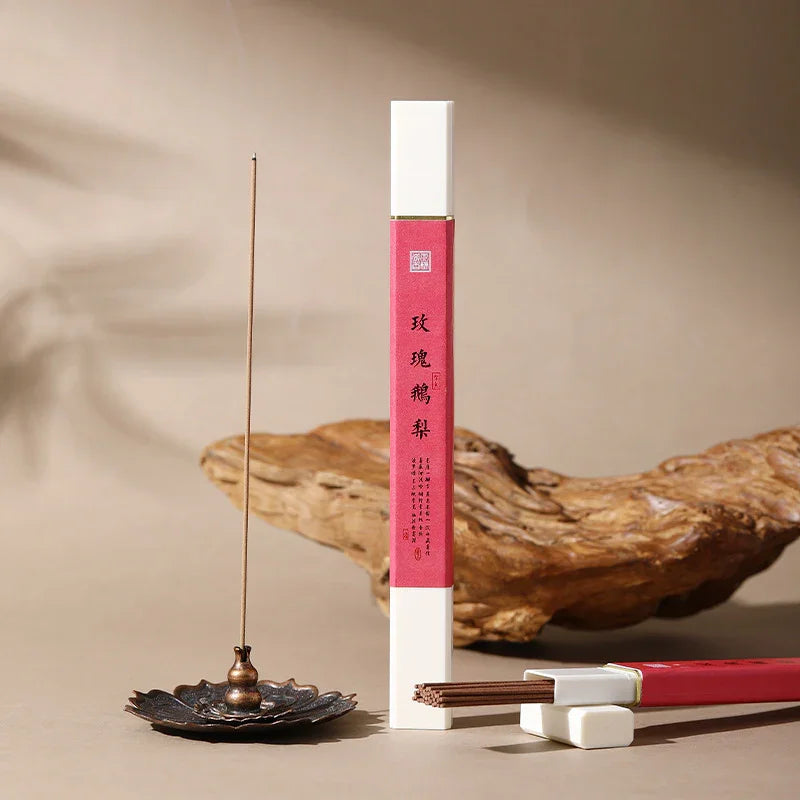 Elegant incense sticks in white and red packaging with traditional holder on wooden surface