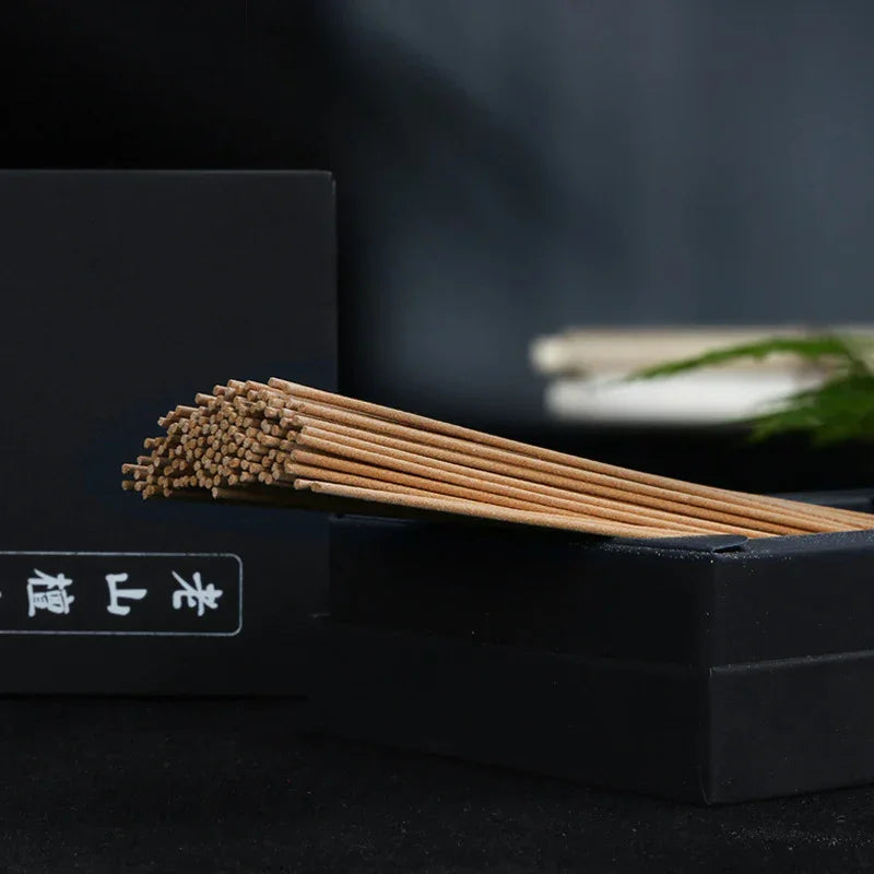 Bundle of natural brown incense sticks on a black box with Chinese characters