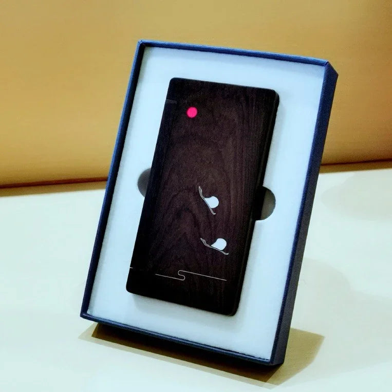 Dark wood smartphone case with white snail design and red dot, displayed in blue and white box