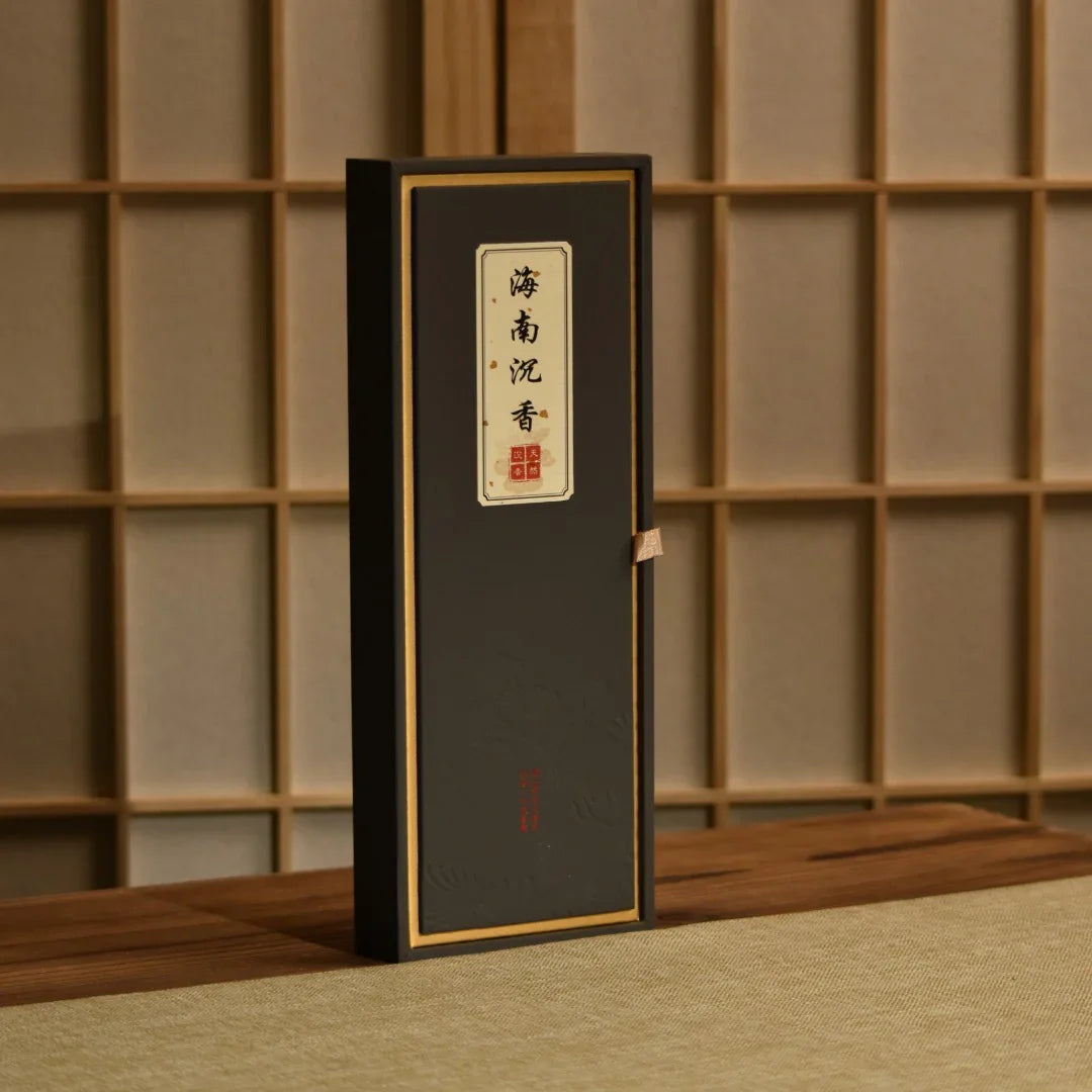 Elegant black rectangular incense box with gold trim and Chinese calligraphy on a wooden table