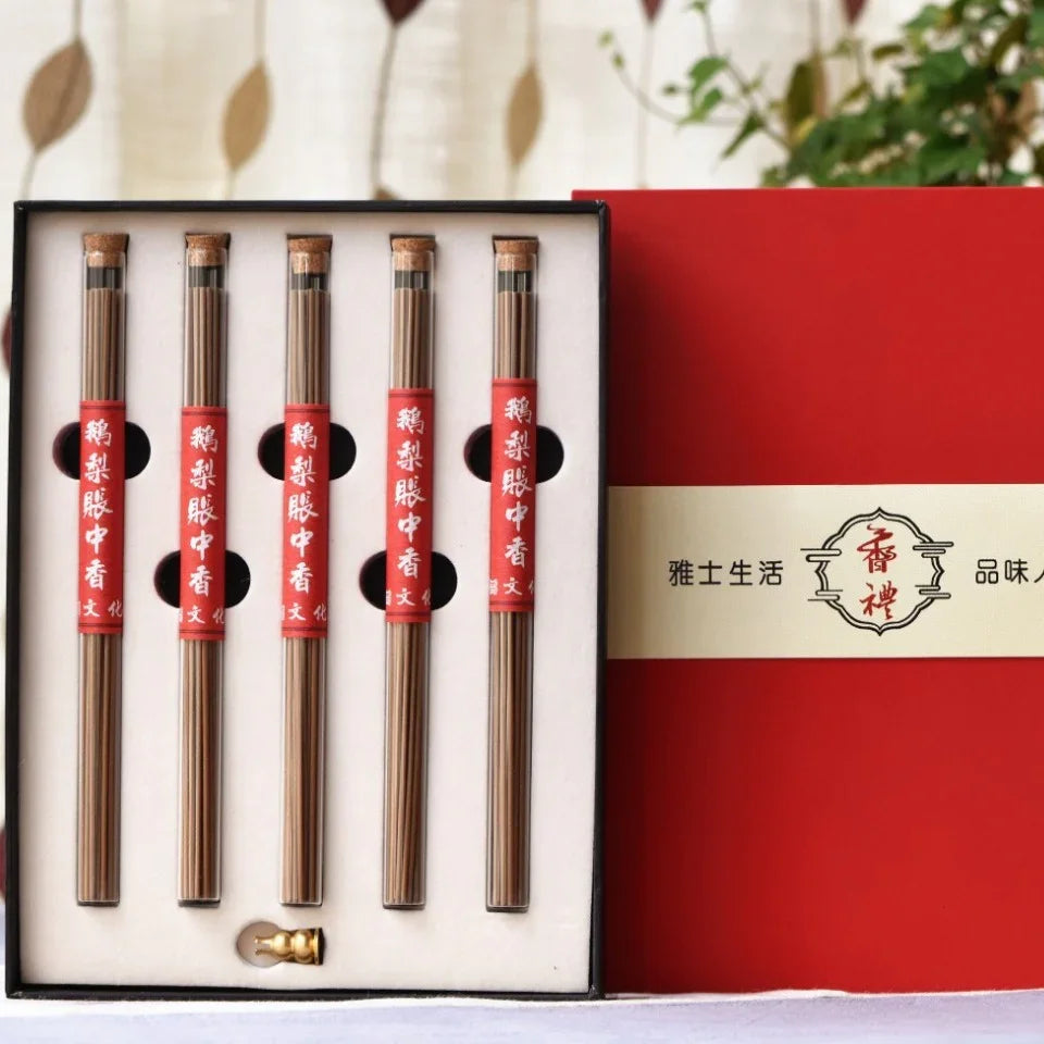Box set of five incense stick bundles in glass tubes with red labels and cork stoppers, beside red and beige packaging