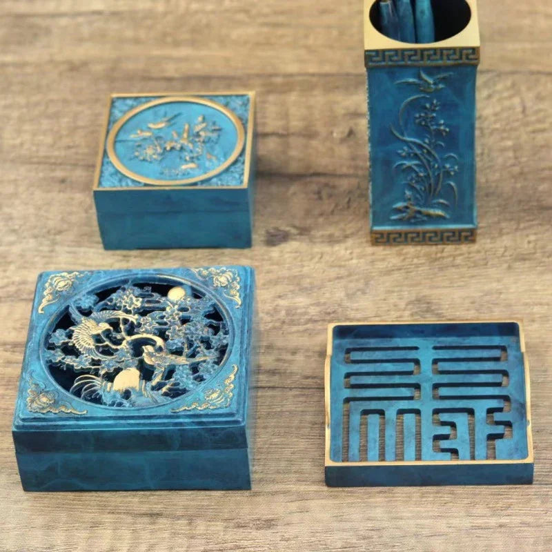 Blue and gold decorative wooden boxes with intricate carvings on a wooden surface