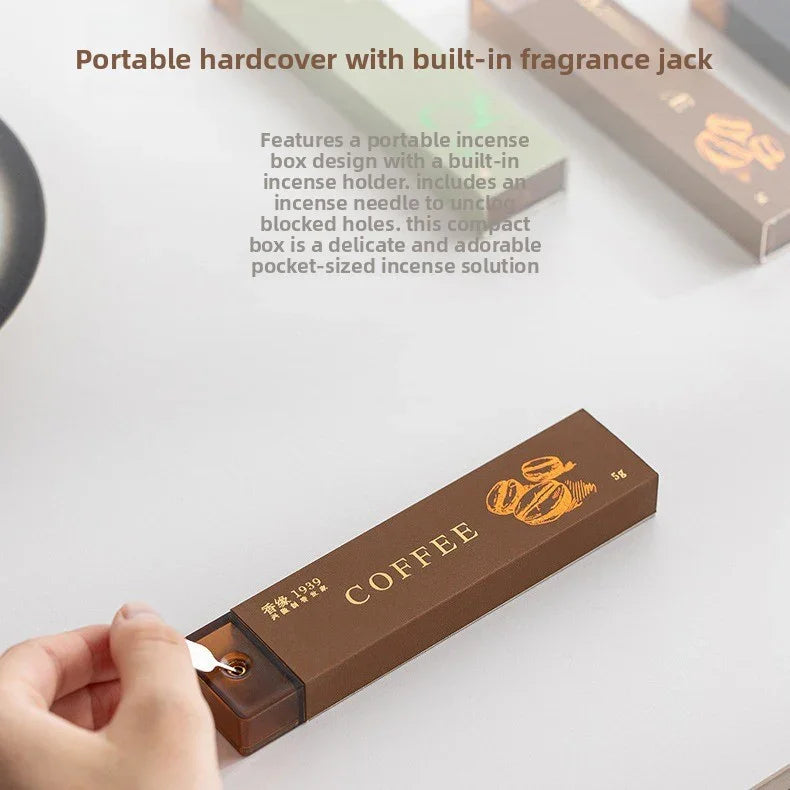 Hand holding an incense needle to adjust a brown portable coffee-scented incense box with gold accents