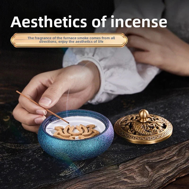 Hand lighting incense stick on blue ceramic holder with decorative golden lid on wooden surface