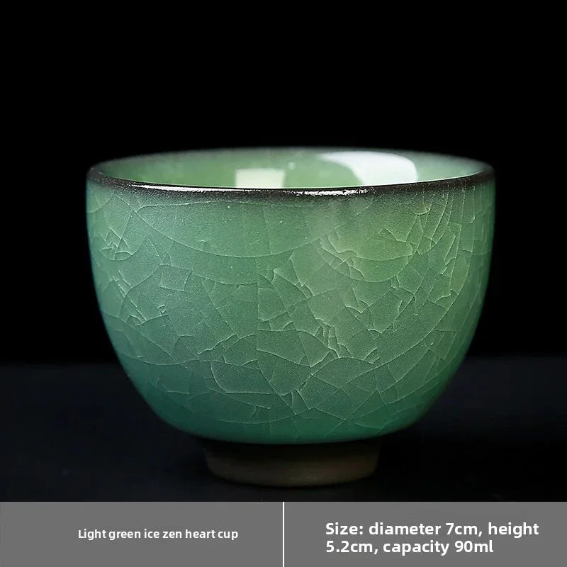 Light green ceramic tea cup with cracked glaze texture on black background