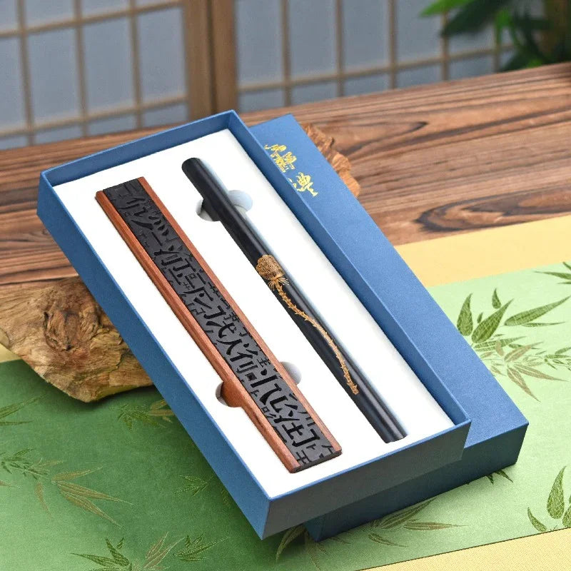 Chinese calligraphy brush and carved ink stick set in blue gift box on wooden table with decorative paper