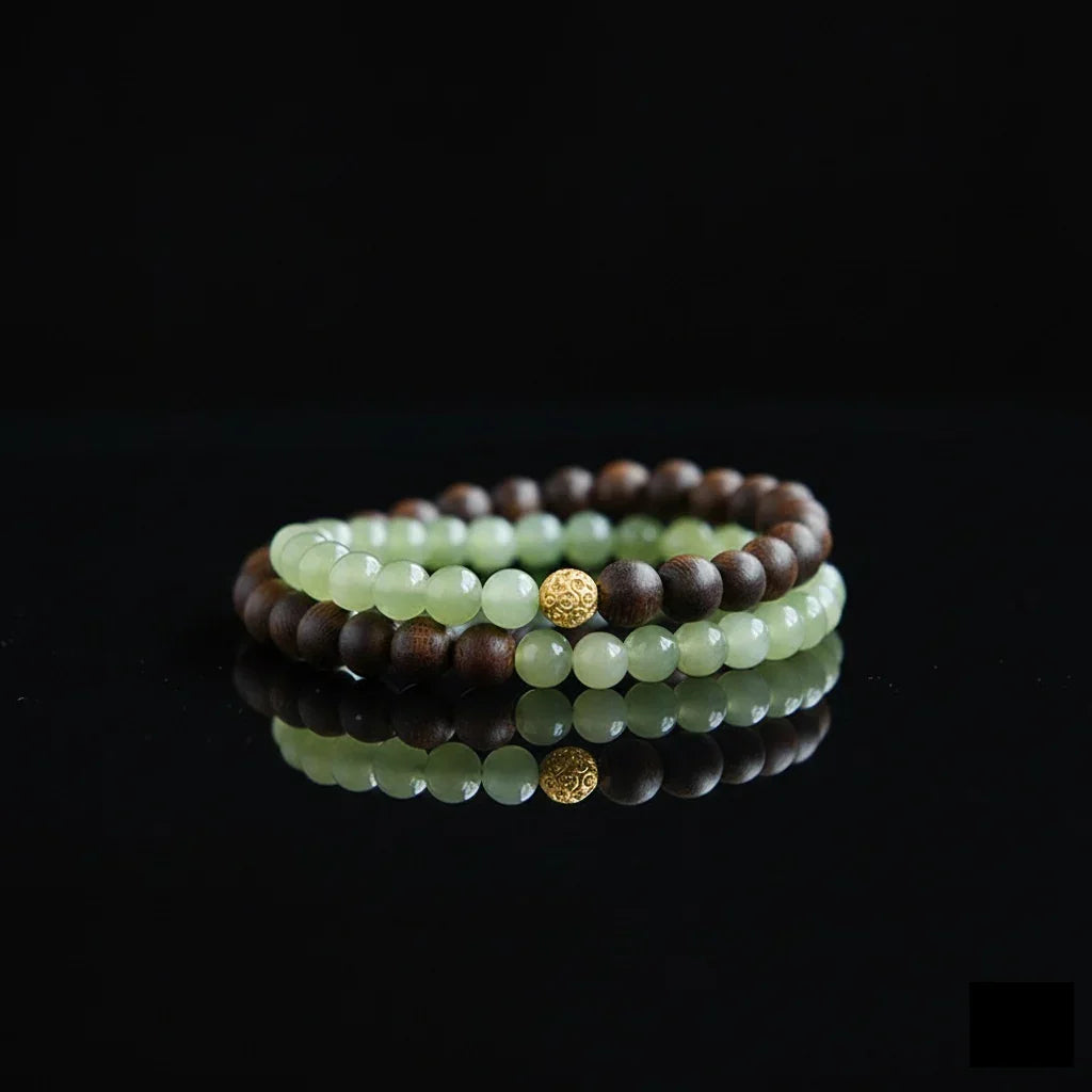 Double-layer beaded bracelet with green jade and dark wooden beads on black reflective surface