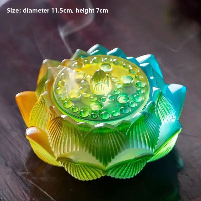 Colorful lotus-shaped glass incense burner emitting smoke on a dark surface