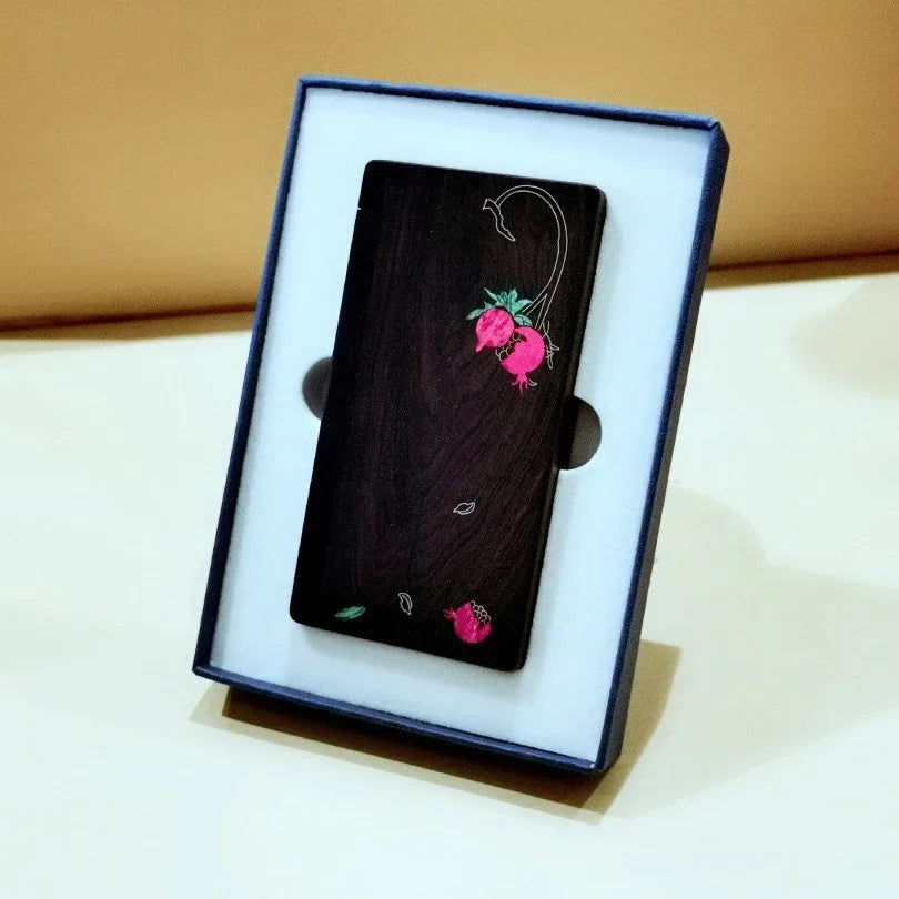 Elegant dark wooden phone case with pink floral design in blue gift box on beige surface
