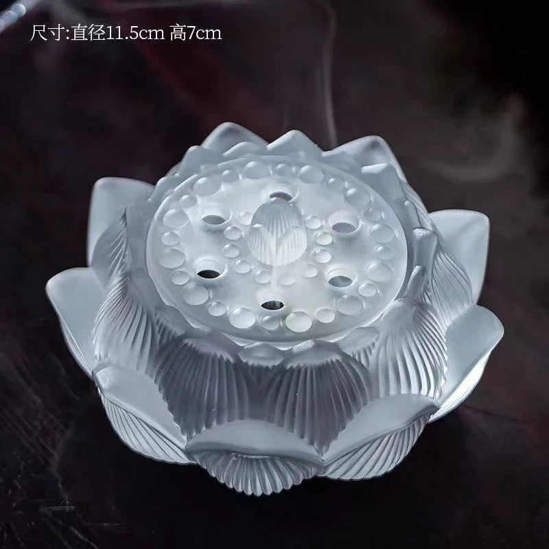 Frosted glass lotus-shaped incense holder with smoke on dark surface
