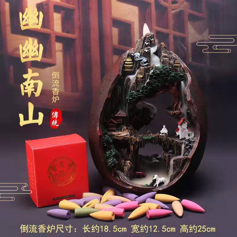 Traditional Chinese backflow incense burner with mountain scene, pagodas, and colorful incense cones