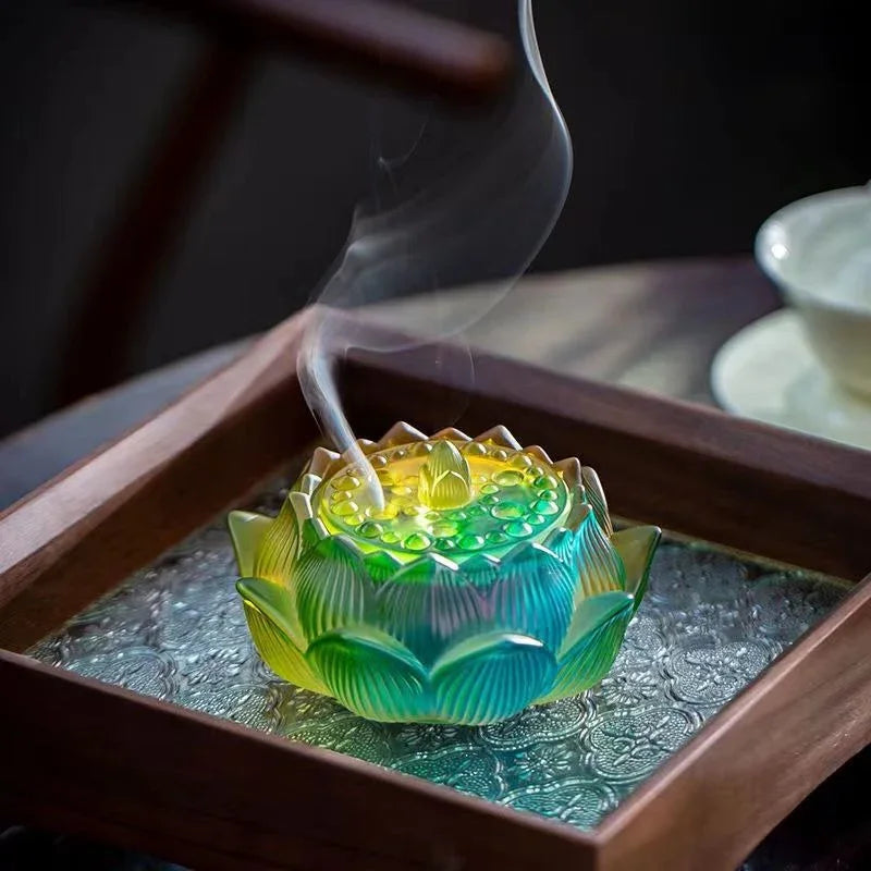 Colorful lotus-shaped incense burner with smoke on a patterned tray in a cozy setting
