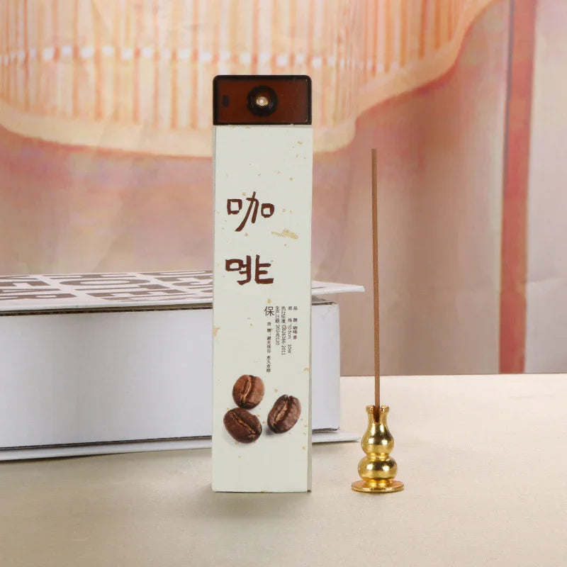 Box of coffee-scented incense sticks with Chinese text and coffee bean images next to a gold incense holder