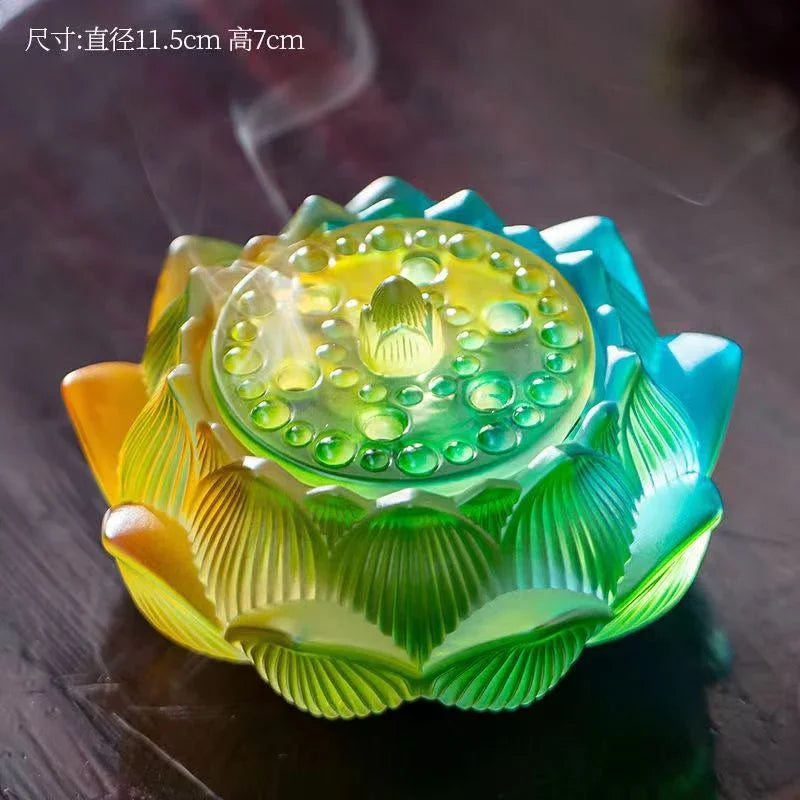Colorful translucent lotus-shaped incense holder with smoke rising on a dark wooden surface
