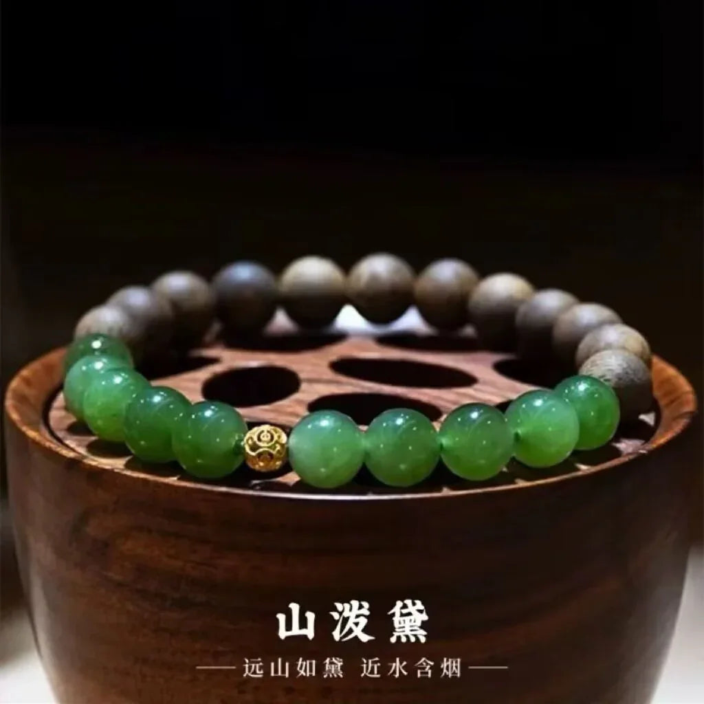 green jade and brown wooden bead bracelet with gold accent on wooden display