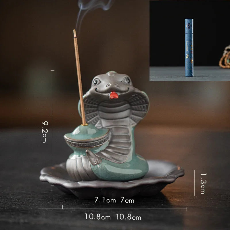 Ceramic cobra incense holder with incense stick and detailed size dimensions on dark surface