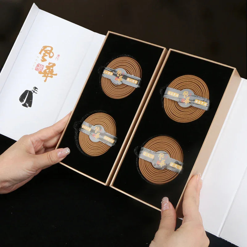 Box of four spiral incense coils in black velvet lining held by hands, elegant Asian packaging with gold lettering