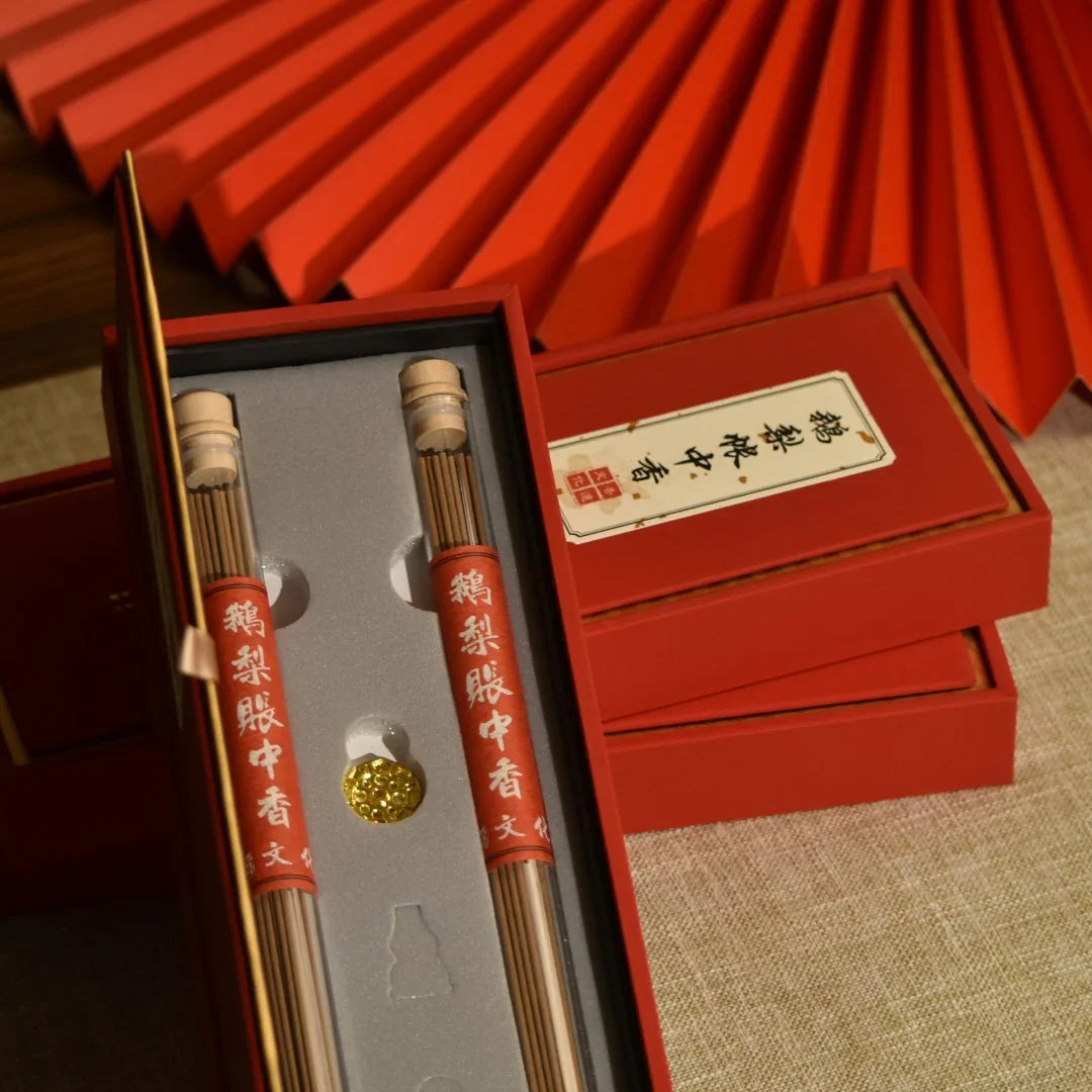 Red gift box with traditional Chinese incense sticks and ornate gold incense holder