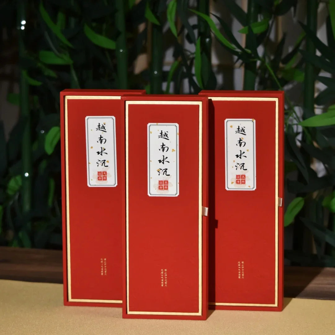 Three red rectangular packaging boxes with gold trim and Chinese characters, set against green bamboo background