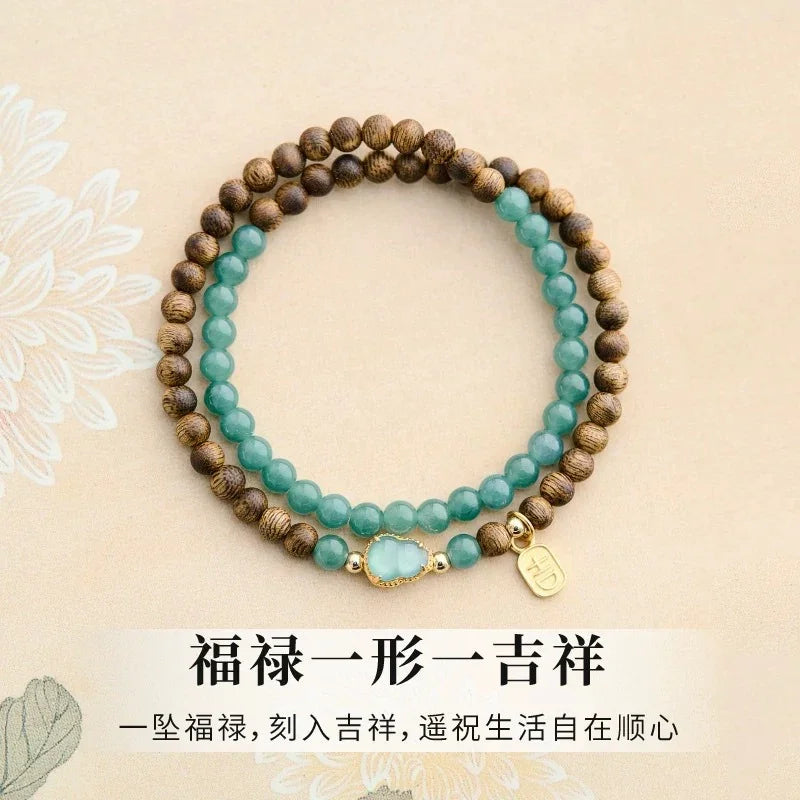 Double-layer bracelet with green jade and wooden beads on beige background with Chinese text