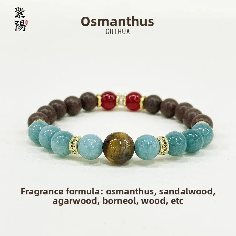 Osmanthus fragrance bracelet with tiger eye, aquamarine, sandalwood, red and wood beads on white background
