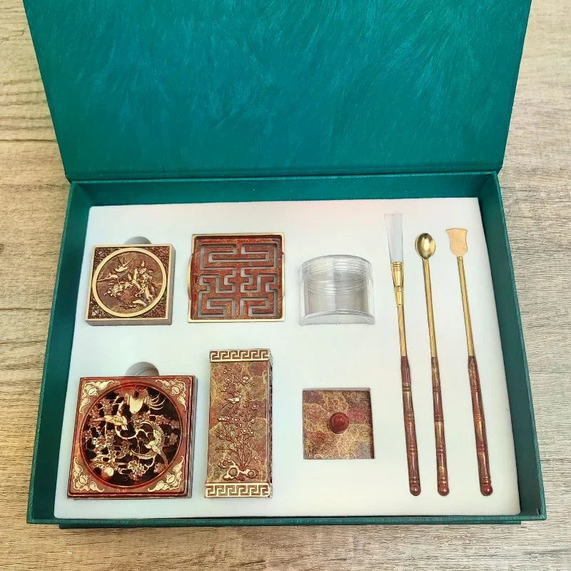 Traditional Chinese calligraphy ink stone set with detailed designs and wooden brush tools in green box