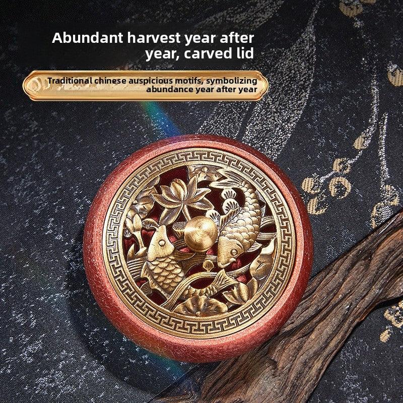 Carved wooden lid featuring traditional Chinese motifs with two koi fish and lotus flowers symbolizing abundance
