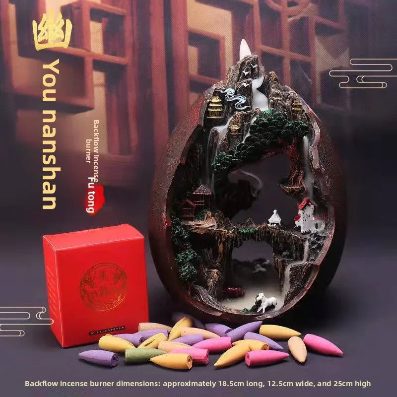 You Nanshan backflow incense burner with intricate mountain temple design, surrounded by colorful incense cones and red packaging