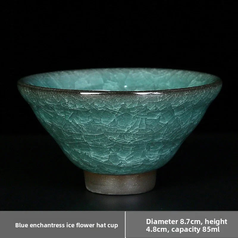 Blue crackled ceramic cup with a flower hat shape on black background