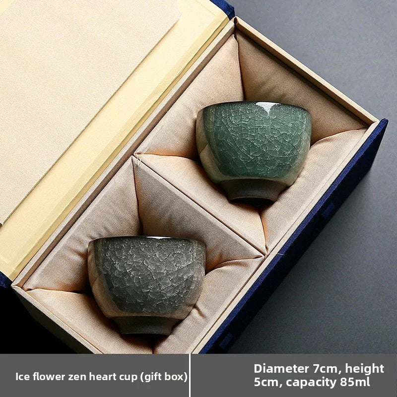 Two crackled ceramic ice flower zen heart cups in green and gray, nestled in padded gift box