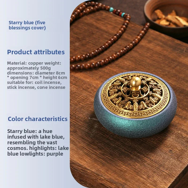 Starry blue copper incense burner with ornate gold lid and wooden prayer beads on dark wood surface